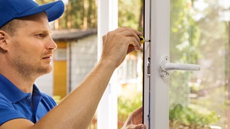 homem de boné e camisola azuis a compor uma janela